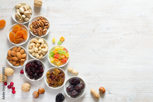 Mix of nuts and dried fruits in small bowls. Healthy and tasty snack 