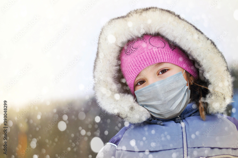 Christmas small girl in medical protective face mask has a winter vacation at a ski resort , winter portrait Christmas small girl in medical protective face mask has a winter vacation at a ski resort , winter portrait