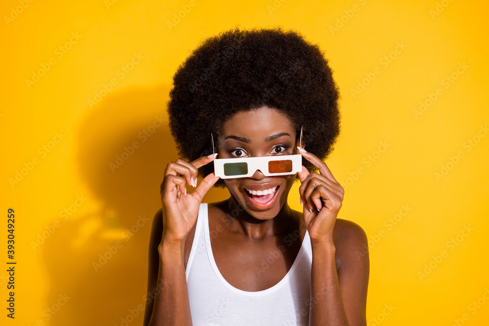 Close-up portrait of nice cheerful wavy-haired girl good mood touching 3d specs watching film isolated over shine yellow color background