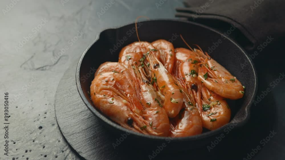 A small cast-iron frying pan with prawns, cooked in spices A small cast-iron frying pan with prawns, cooked in spices