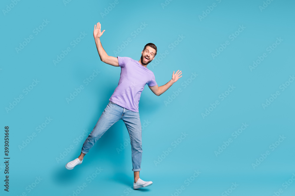Full length body size photo of young student dancing fooling wearing jeans casual t-shirt sneakers isolated on bright blue color background