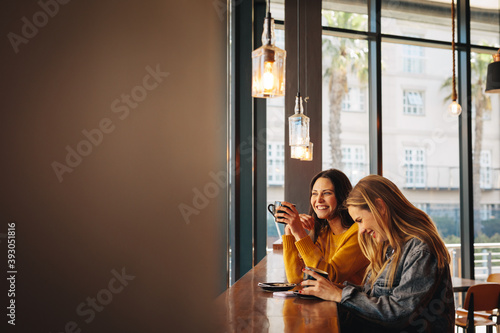 Tableau sur toile Friends chatting while drinking coffee