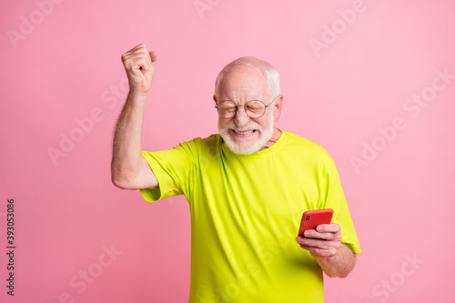 Photo of ecstatic handsome aged guy closed eyes fist up triumph celebrate wear lime isolated on pink color background