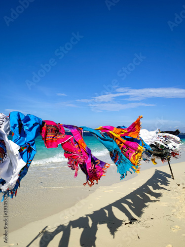 Multi-colored clothes fluttering in the wind on the shore of indian ocean