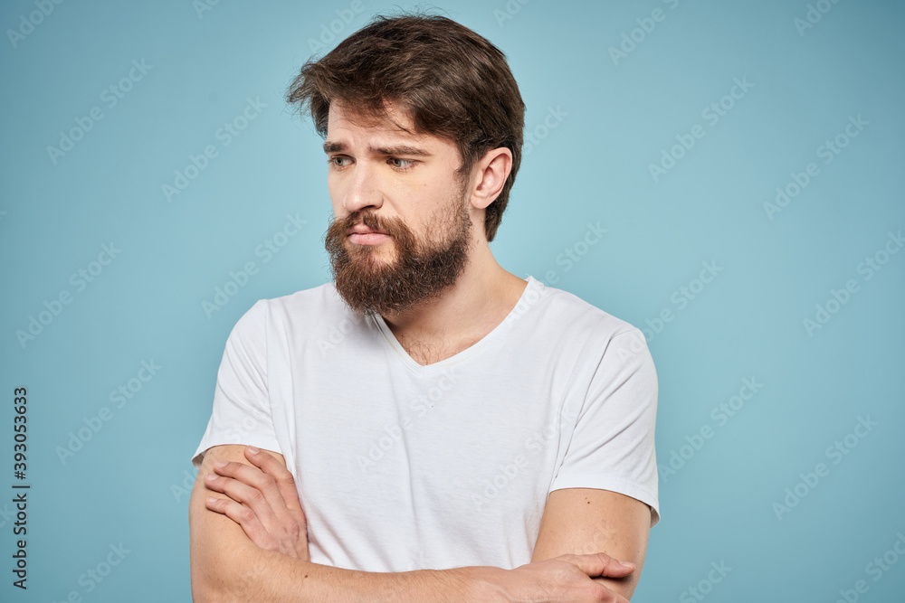 Obraz premium Man in white t-shirt lifestyle studio emotions facial expression blue isolated background