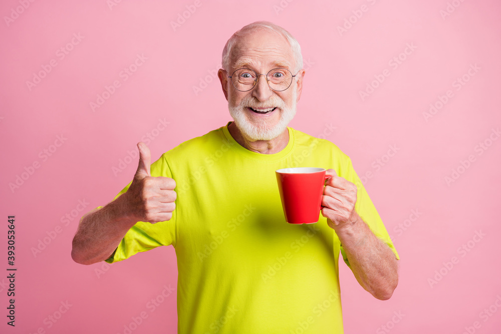Portrait of funky pensioner show approval sign hold cup wear spectacles lime color t-shirt isolated on pastel pink color background Portrait of funky pensioner show approval sign hold cup wear spectacles lime color t-shirt isolated on pastel pink color background