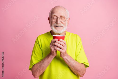 Portrait of funky pensioner hold cup smell coffee wear spectacles lime color t-shirt isolated on pastel pink color background © deagreez