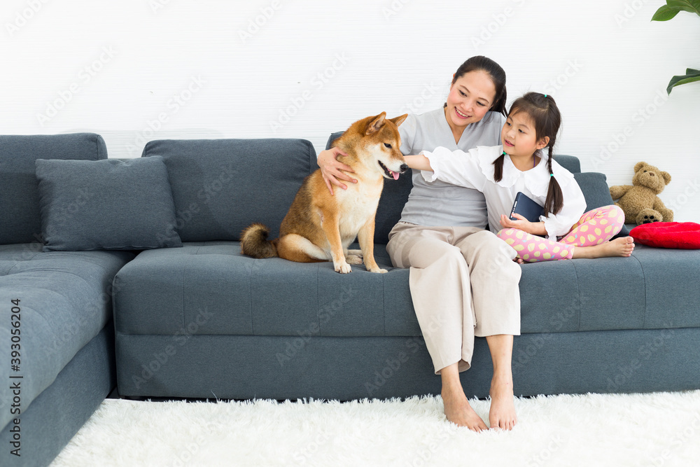 Lovely family, mother and daughter with their favorite dog sit on sofa. Lovely family, mother and daughter with their favorite dog sit on sofa.