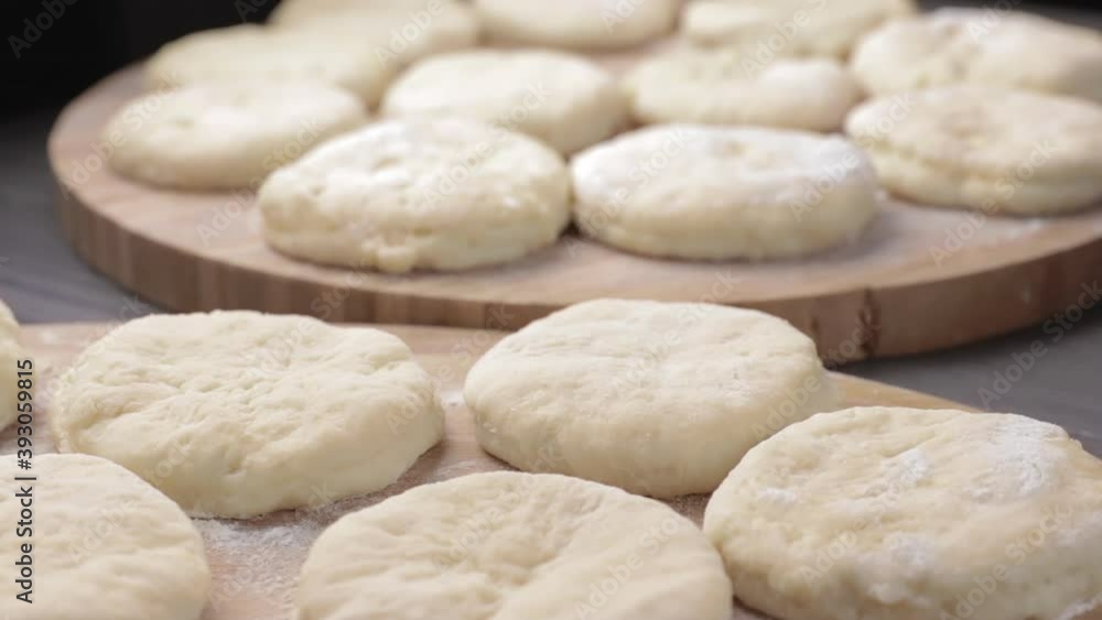 food background with many round slices of yeast dough and white flour on a wooden cutting board food background with many round slices of yeast dough and white flour on a wooden cutting board
