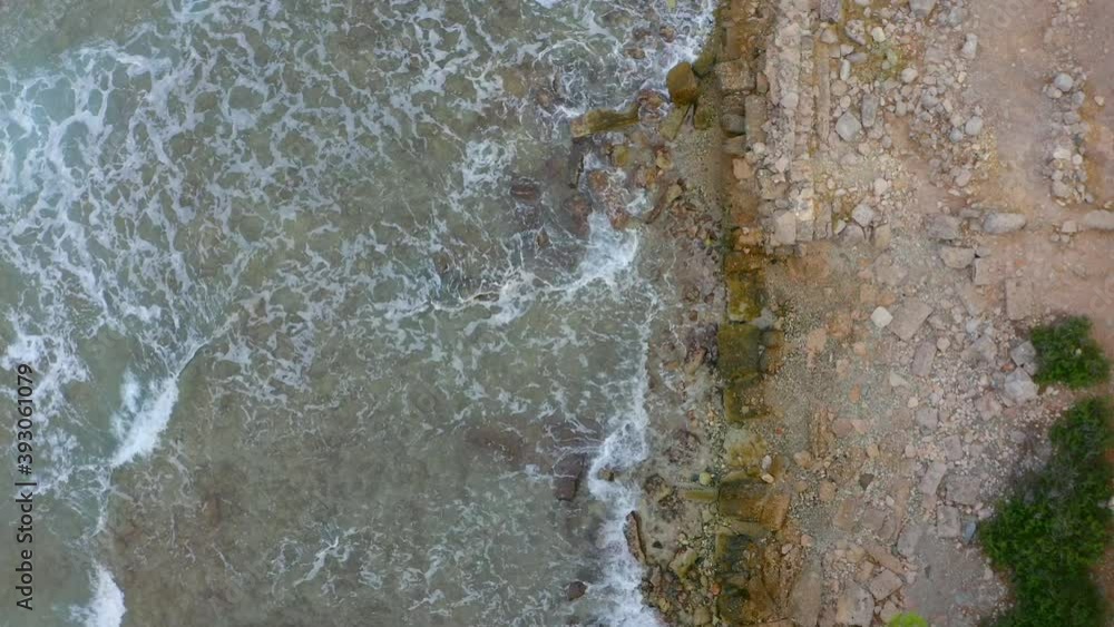 Flying above coast, slow motion aerial view of powerful sea waves crashing at seashore with foam and splashing. Aerial view on south of Turkey rocky coastline. Ancient city Phaselis. Top view Flying above coast, slow motion aerial view of powerful sea waves crashing at seashore with foam and splashing. Aerial view on south of Turkey rocky coastline. Ancient city Phaselis. Top view