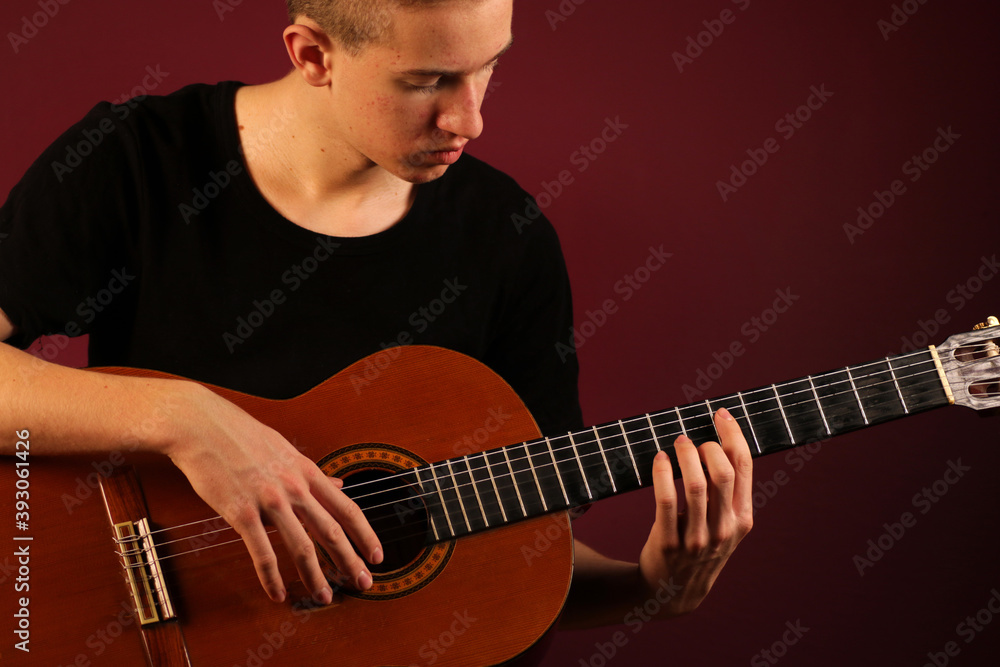 Young man playing classic acoustic guitar
