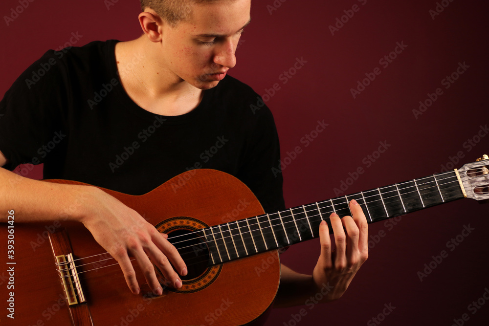Obraz premium Young man playing classic acoustic guitar
