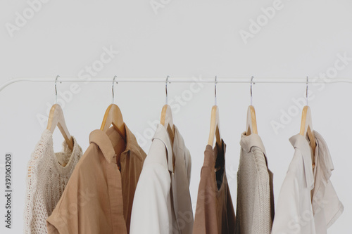 Collection of female clothes hanging on a rack.
