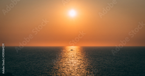 Dramatic sea sunset with the only fishing boat. Loneliness at the sea. Isolated fisherman in the sunset. Isolation and loneliness concept.