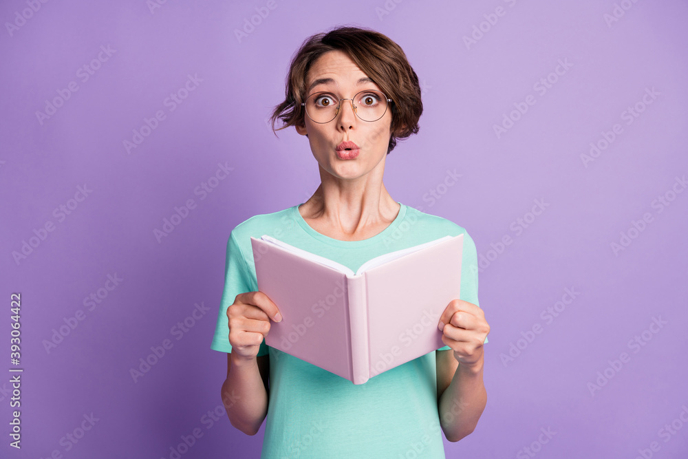 Photo of nice impressed short brown hairdo lady read planner wear spectacles blue t-shirt isolated on violet background Photo of nice impressed short brown hairdo lady read planner wear spectacles blue t-shirt isolated on violet background
