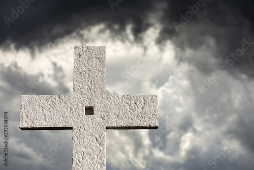 Christian cross made of white stone on dramatic sky, near the small village of Sant'Anna d'Alfaedo, Lessinia plateau, Verona, Italy, Europe.