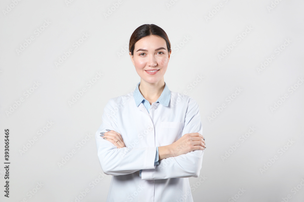 Young woman doctor on light background with place to place text Young woman doctor on light background with place to place text