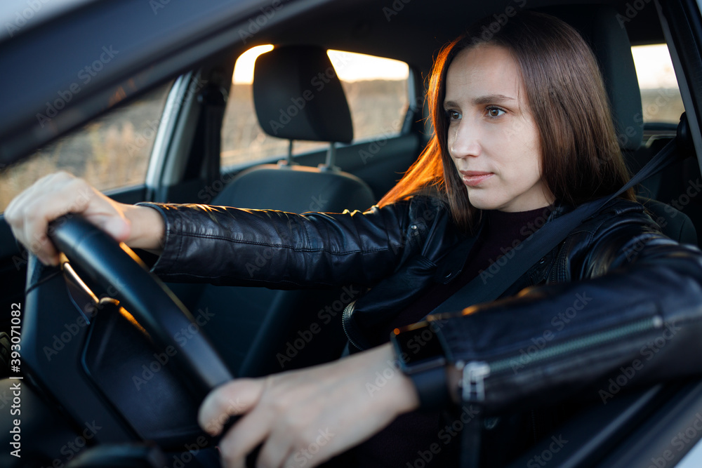 Attentive and stylish female driver in the car Attentive and stylish female driver in the car
