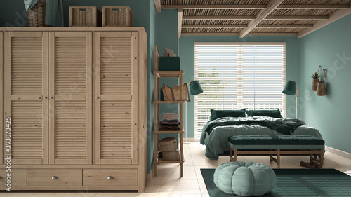Cosy wooden peaceful bedroom in turquoise tones, double bed, pillows and blankets, ceramic tiles floor, carpet, pouf, shelves, big vintage wardrobe and window, modern interior design
