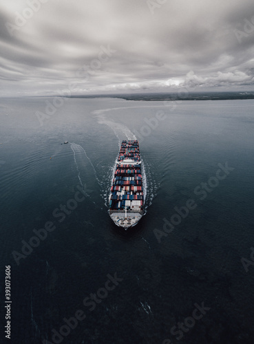 Container ship on an overcast day, heading out from port