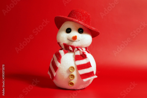 Handsome snowman in hat and scarf on red background, Christamas concept. © Stan Hubble