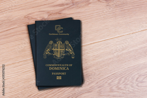 Fotografi two dominica passports on white wood background, space for texts