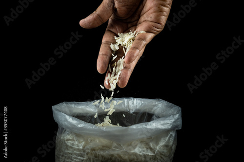 Human hand with thin flattened rice gram in a bowl