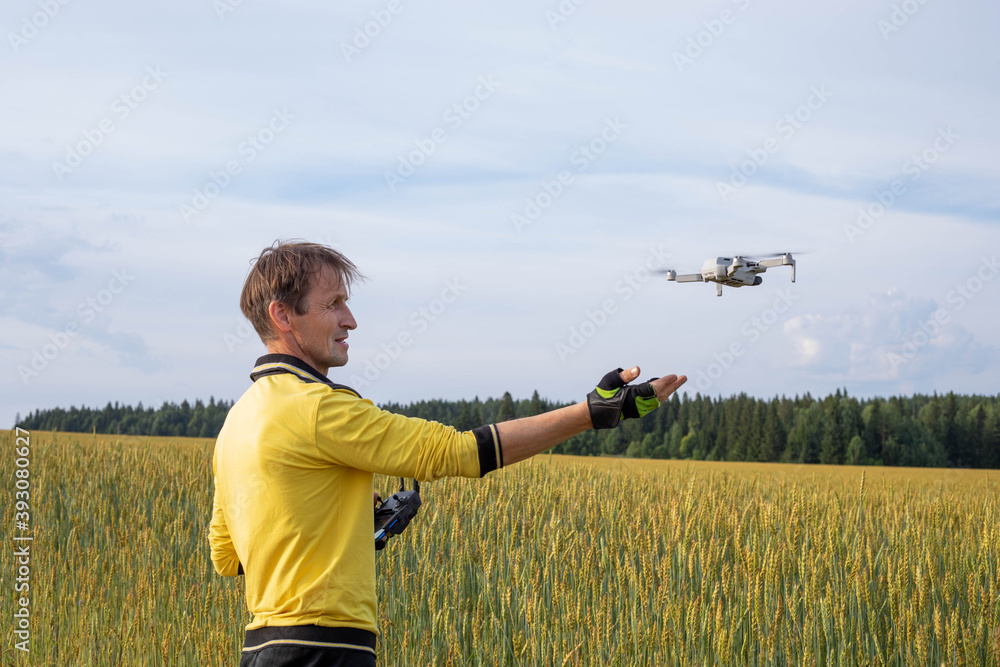 A man launches a drone by nature. Quadcopter flies in front of a man A man launches a drone by nature. Quadcopter flies in front of a man