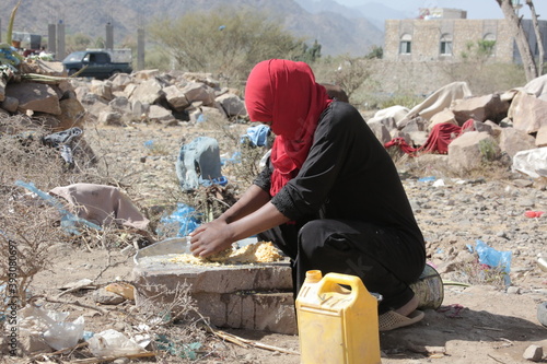 Yemeni woman makes food for her homeless children in displacement campsin the city of Taiz after the Houthi militia displaced them and drove them out Their homes