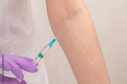 Close up nurse hands on gloves makes an injection to hand patient