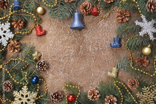 Christmas decorations, branches with cones, toys, on a brown background. With space for text. New year background.