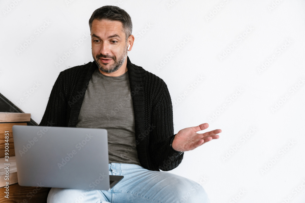 Attractive confident young man using laptop Attractive confident young man using laptop