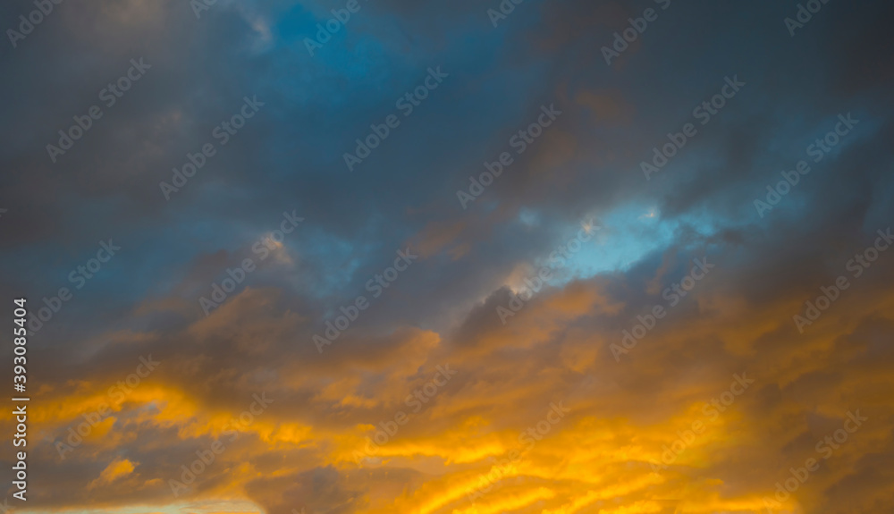 Colorful yellow grey clouds in a blue sky at sunrise in autumn, Almere, Flevoland, The Netherlands, November 16, 2020