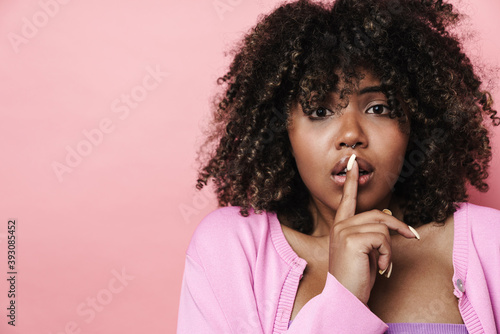 Scared african american woman showing silence gesture at camera