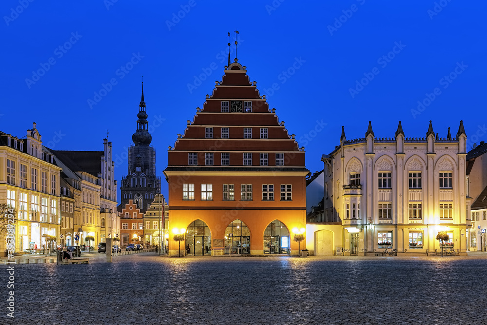Greifswald, Germany. Evening view of Market square with Town Hall (center), Town Hall Pharmacy (right) and Cathedral of St. Nicholas (left on background).