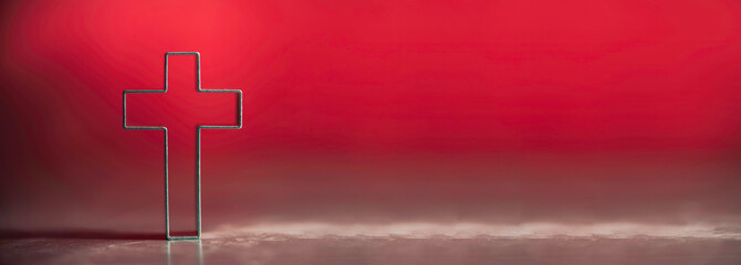 Christian cross on red background with soft bokeh lights background. Copy space. Banner. Church worship, salvation concept. Faith symbol in Jesus Christ. Holy cross for good friday, Easter day