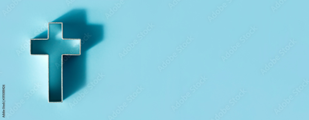 Obraz premium Silhouette of christian cross on blue background, soft bokeh lights background. Copy space. Church worship, salvation concept. Faith symbol in Jesus Christ. Holy cross for Christmas, Easter day