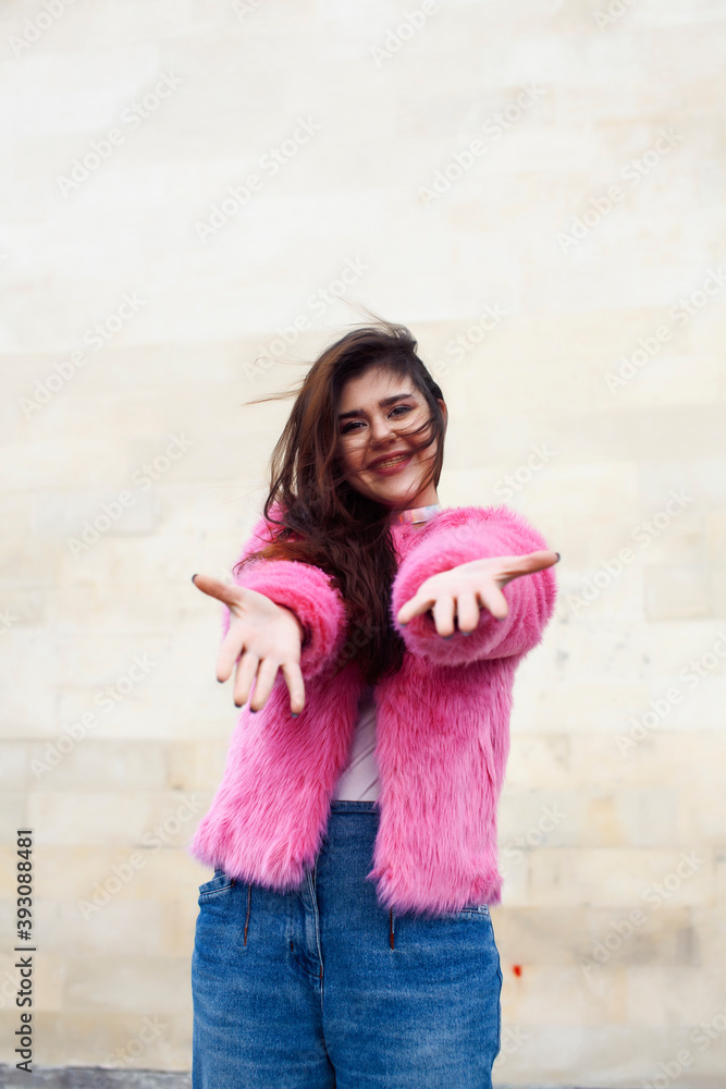 young cute girl teenager in pink fur coat gesturing hanging around outdoor , lifestyle people concept