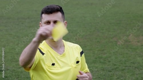 Football Soccer referee whistles and shows penalty and yellow, red card