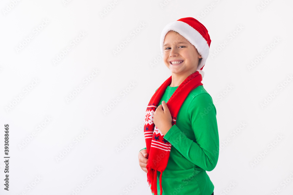 Portrait of happy boy wearing Santa Claus hat and winter scarf. Merry Christmas time. Portrait of happy boy wearing Santa Claus hat and winter scarf. Merry Christmas time.