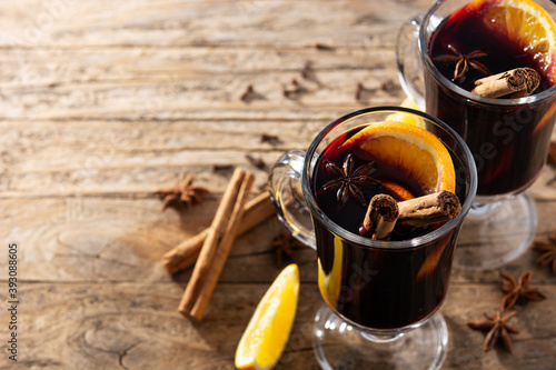 Traditional mulled wine with spices on wooden table. Copy space