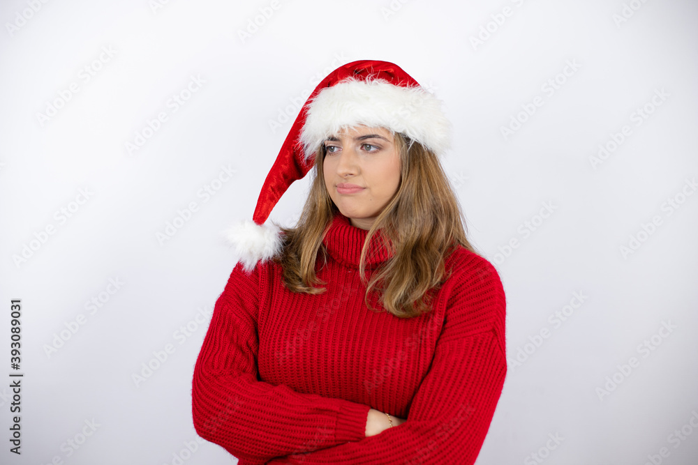 Young pretty blonde woman wearing a red casual sweater and a christmas hat over white background thinking looking tired and bored with crossed arms Young pretty blonde woman wearing a red casual sweater and a christmas hat over white background thinking looking tired and bored with crossed arms