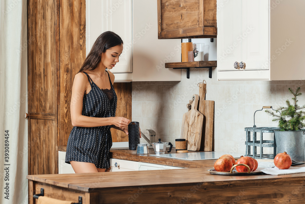 Mixed race woman pouring ground coffee into the coffee maker Mixed race woman pouring ground coffee into the coffee maker