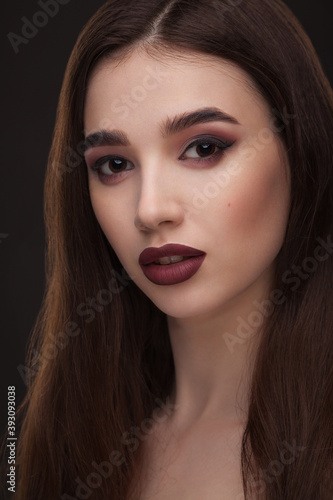 portrait of a beautiful girl with skillful makeup on a dark background