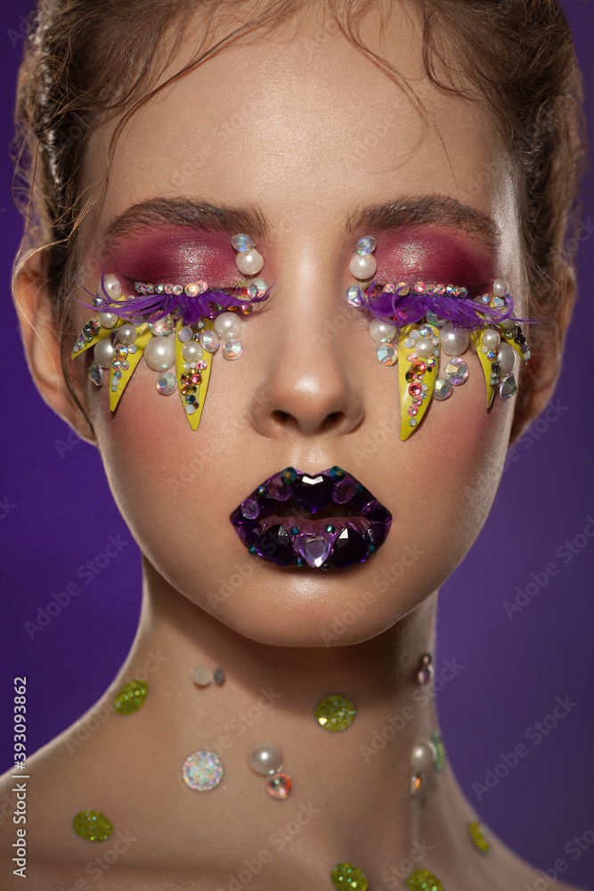 Fototapeta premium portrait of a beautiful girl with skillful bright fantasy makeup