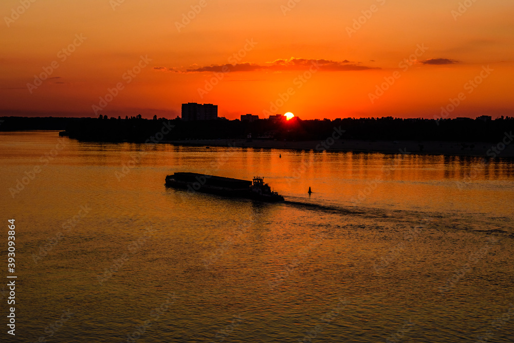 Long heavy barge on a Dnieper river near city Kremenchug at sunset Long heavy barge on a Dnieper river near city Kremenchug at sunset