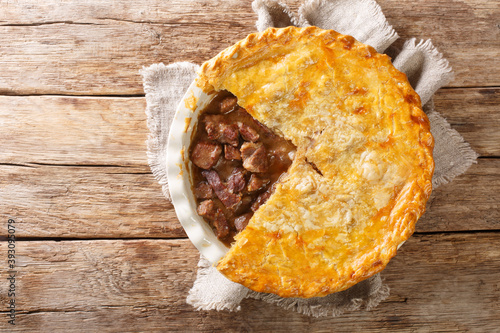 Konstfotografi English beef steak pie with crispy puff pastry close-up in a baking dish on the table