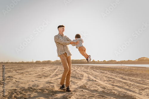 Portrait of loving father and his one years old son walking and playing outdoors © Lena May