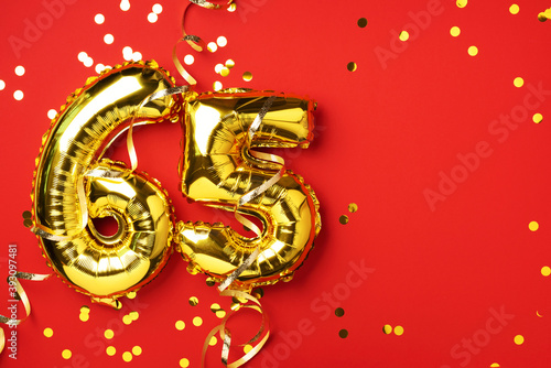 Gold foil balloon number, digit sixty-five. Birthday greeting card with inscription 65. Anniversary celebration event. Banner. Golden numeral, red background. Numerical digit, bright shiny glitter