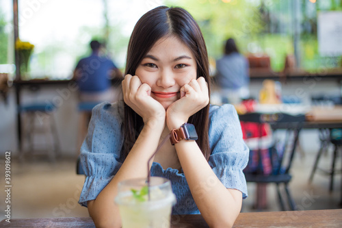 Asian women sitting in modern cafe drinking ice lemon soda © themorningglory